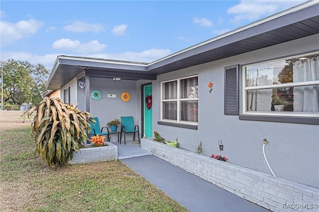 view of exterior entry with a yard