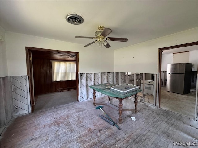 rec room featuring a ceiling fan, wainscoting, wood finished floors, and wooden walls