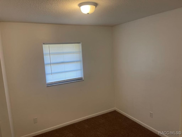 carpeted spare room featuring a textured ceiling