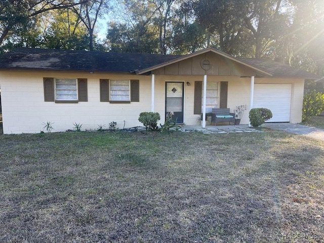 ranch-style home with a garage, a porch, and a front lawn