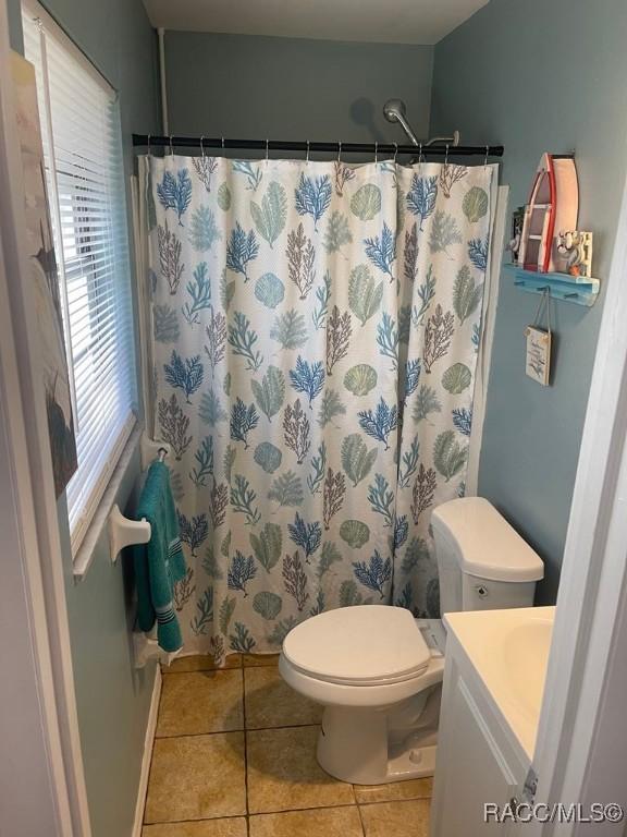 bathroom featuring vanity, curtained shower, tile patterned floors, and toilet