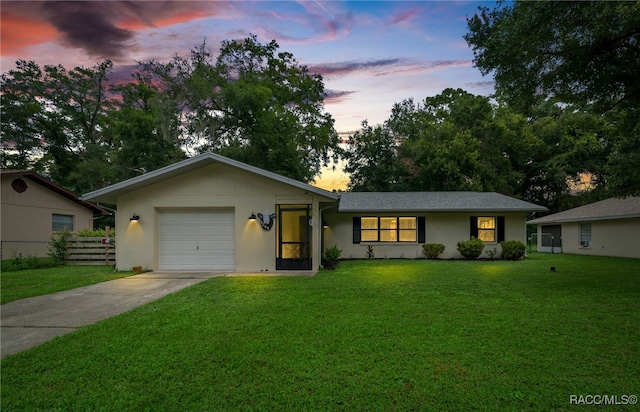 single story home featuring a yard and a garage