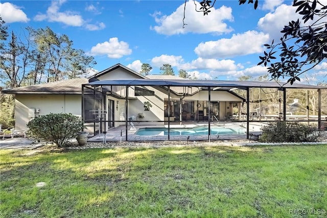 back of property with glass enclosure, a patio area, and a yard