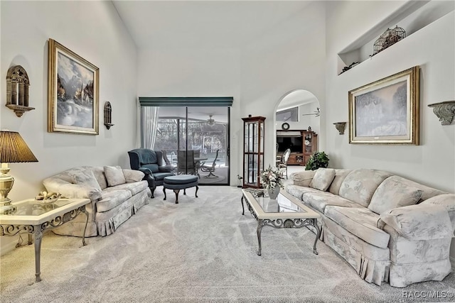 living room featuring carpet flooring and a high ceiling