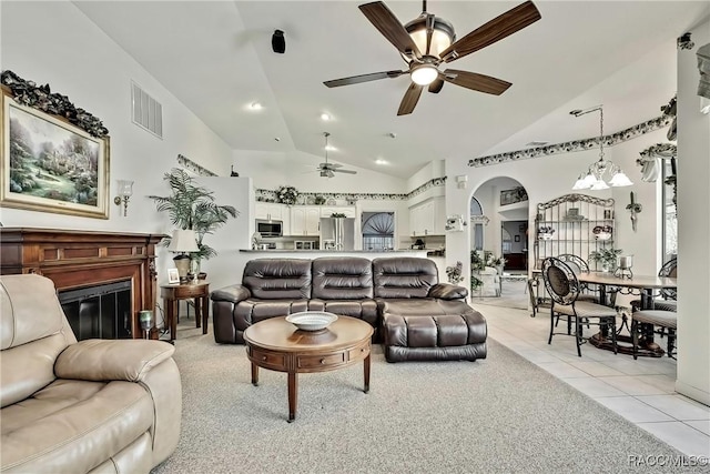 living room with ceiling fan with notable chandelier, light tile patterned flooring, and lofted ceiling