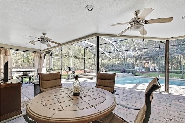 view of patio / terrace with ceiling fan and a lanai