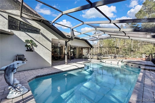 view of swimming pool with glass enclosure, ceiling fan, and a patio