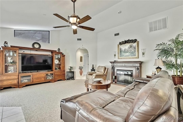 living room featuring ceiling fan, high vaulted ceiling, and light carpet