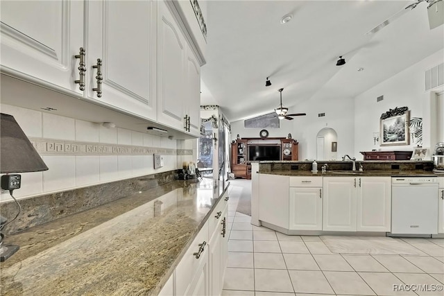 kitchen with white cabinets, white dishwasher, vaulted ceiling, and dark stone countertops