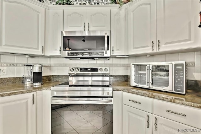 kitchen featuring tile patterned floors, white cabinetry, tasteful backsplash, and stainless steel appliances