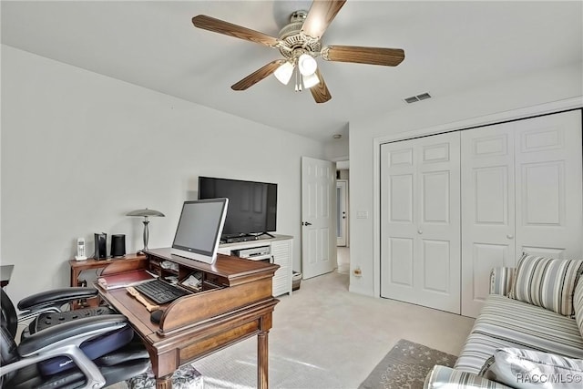 carpeted office space featuring ceiling fan