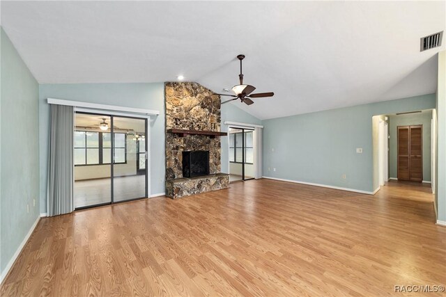 220 E Liberty St, Hernando, FL 34442 - unfurnished living room featuring a ceiling fan, lofted ceiling, a stone fireplace, and light wood-style flooring