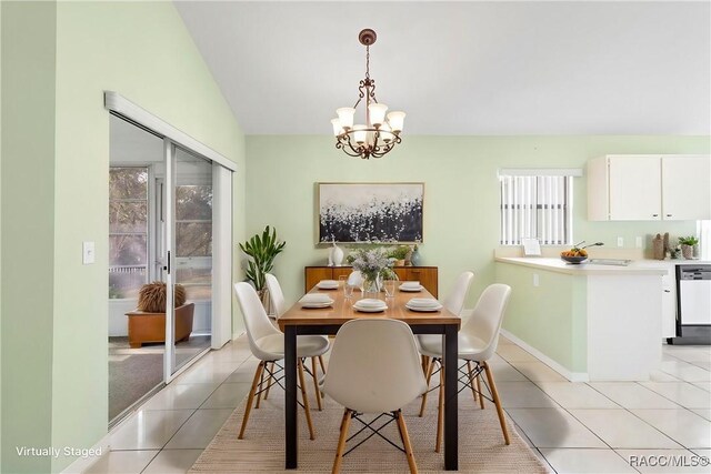 dining space with a chandelier, light tile patterned floors, vaulted ceiling, and sink