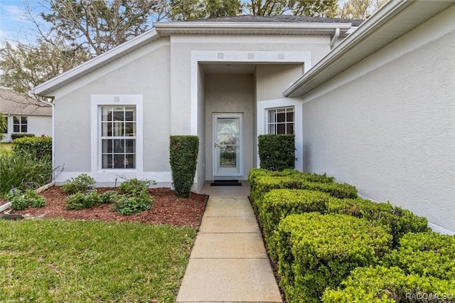 view of exterior entry with stucco siding