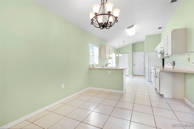 kitchen featuring hanging light fixtures, a peninsula, light countertops, white cabinetry, and light tile patterned flooring