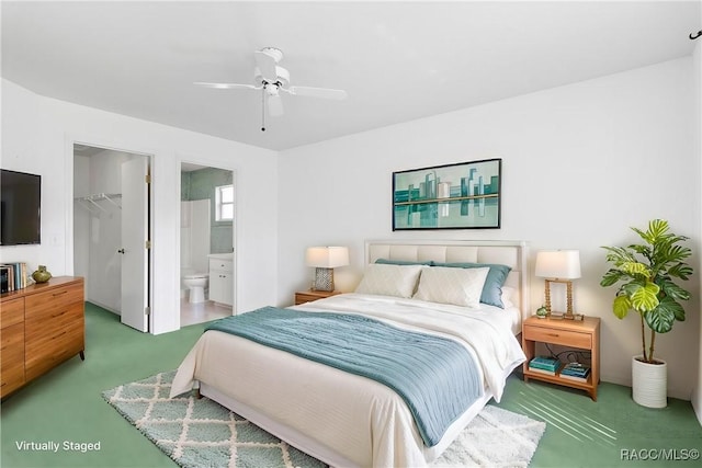 bedroom with carpet, a walk in closet, a closet, a ceiling fan, and ensuite bath