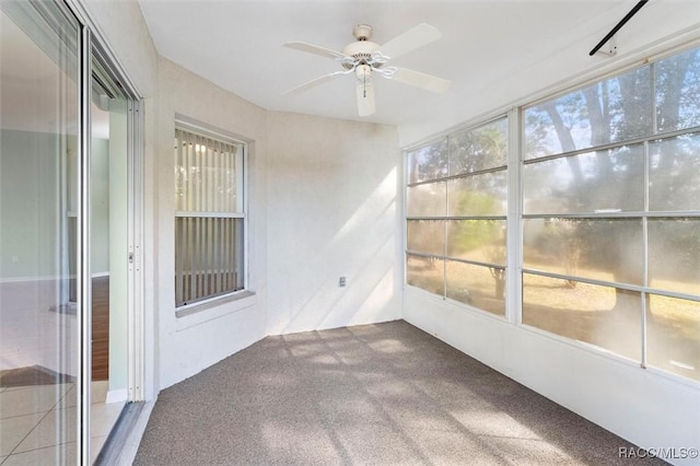 unfurnished sunroom with ceiling fan