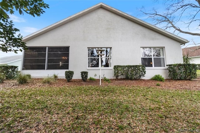 view of side of property with a yard and stucco siding