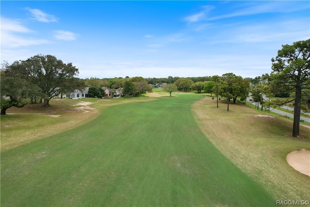 surrounding community featuring view of golf course and a yard