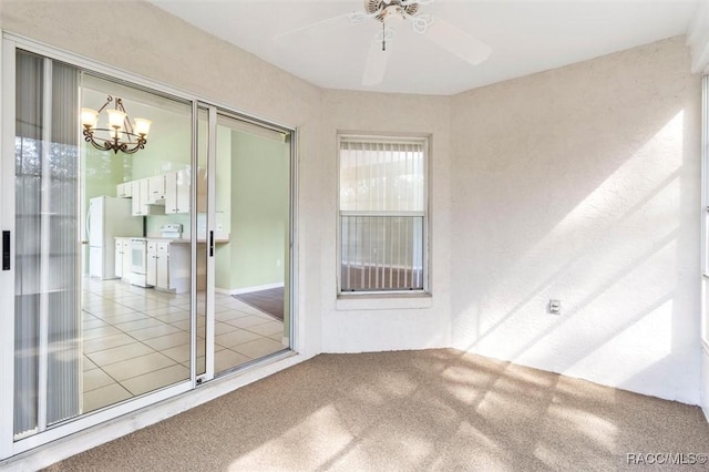 unfurnished sunroom featuring ceiling fan with notable chandelier