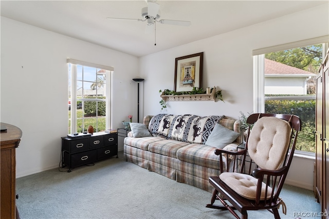 living room with a wealth of natural light, carpet floors, and ceiling fan