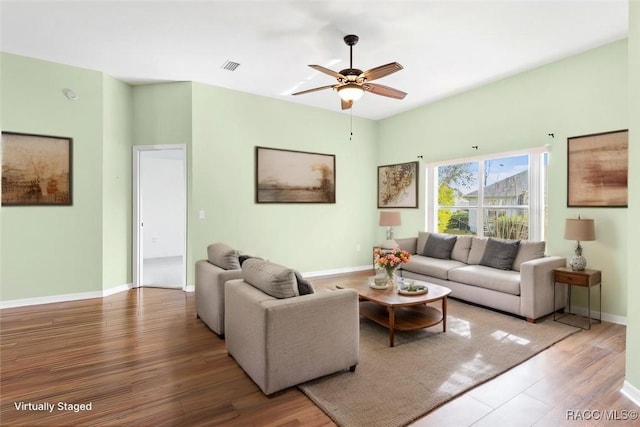 living area with baseboards, visible vents, ceiling fan, and wood finished floors