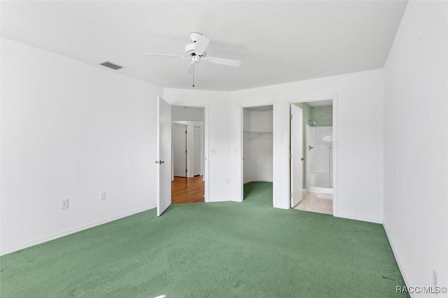 unfurnished bedroom featuring ceiling fan, carpet flooring, visible vents, a closet, and ensuite bath