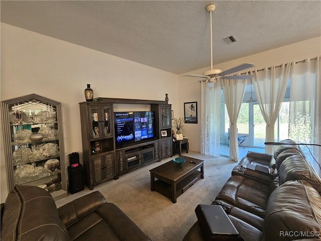 carpeted living room featuring ceiling fan and a textured ceiling