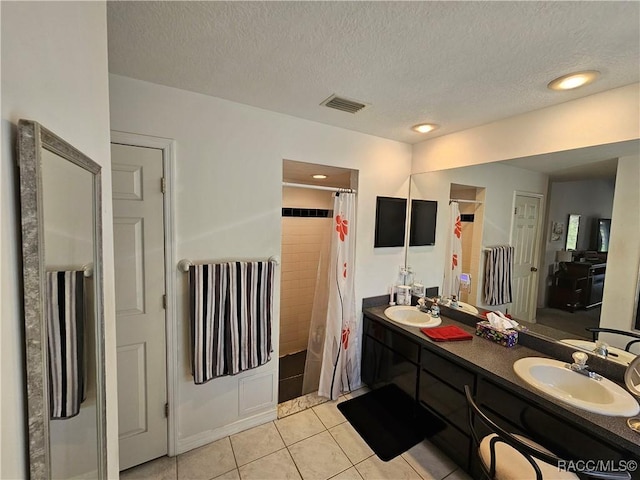 bathroom featuring walk in shower, tile patterned floors, vanity, and a textured ceiling