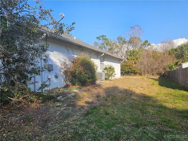 view of side of home with a yard and cooling unit