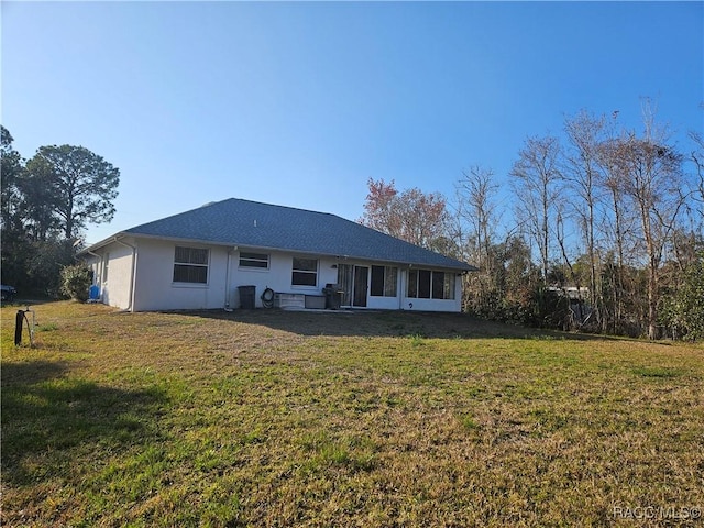 rear view of house with a sunroom and a lawn