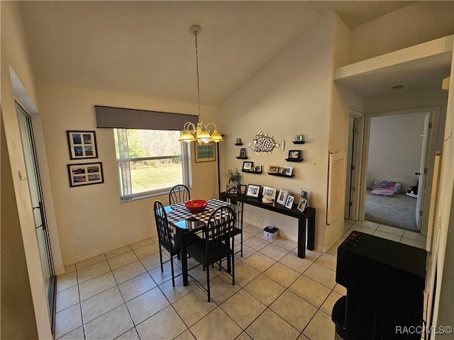 tiled dining room featuring lofted ceiling and a chandelier