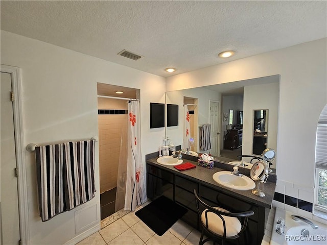 bathroom featuring vanity, tile patterned floors, a textured ceiling, and walk in shower