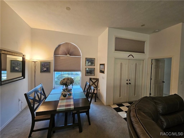 dining space with light carpet and a high ceiling