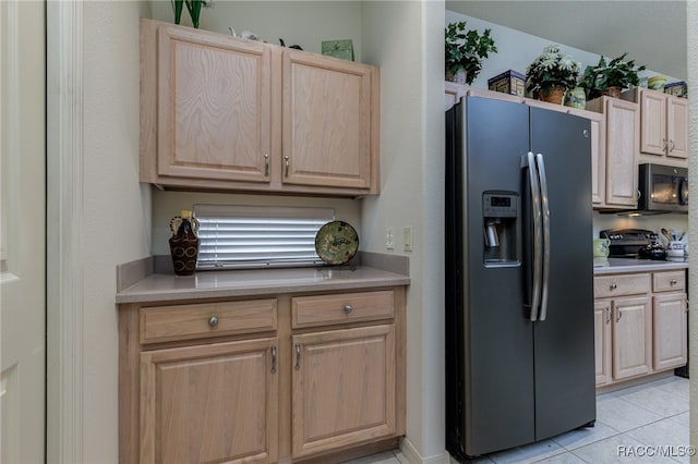 kitchen with stainless steel refrigerator with ice dispenser, light brown cabinets, range with electric cooktop, and light tile patterned flooring