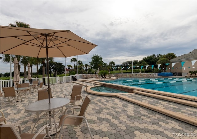 view of swimming pool featuring a patio area and a hot tub