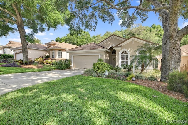 mediterranean / spanish-style home featuring a garage and a front lawn