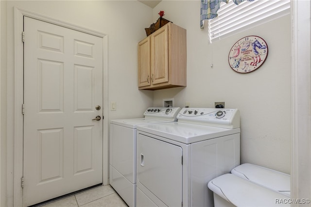 laundry area with cabinets, light tile patterned floors, and washing machine and dryer