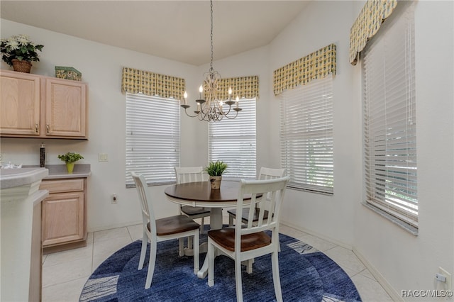 tiled dining space featuring a chandelier and vaulted ceiling