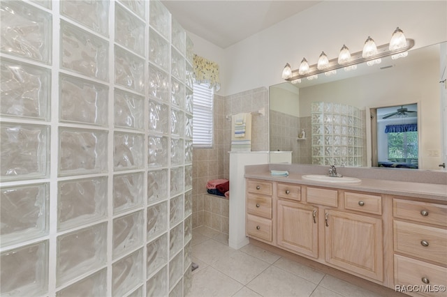 bathroom featuring tile patterned floors, vanity, ceiling fan, and tiled shower