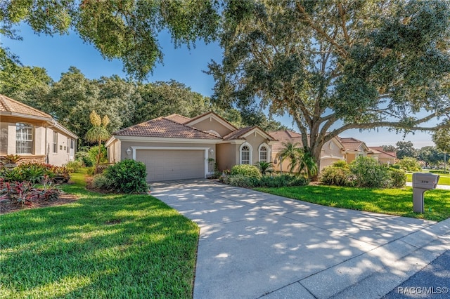 mediterranean / spanish house featuring a garage and a front lawn