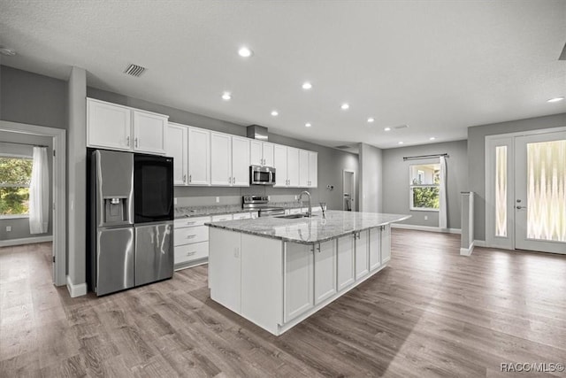 5352 W Corral Pl NW, Beverly Hills, FL 34465 - kitchen featuring appliances with stainless steel finishes, a center island with sink, white cabinets, recessed lighting, and light stone countertops