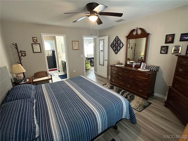 bedroom featuring connected bathroom, light hardwood / wood-style flooring, and ceiling fan