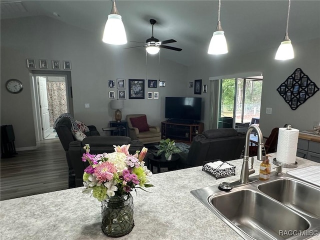 kitchen with sink, vaulted ceiling, hanging light fixtures, dark hardwood / wood-style flooring, and ceiling fan