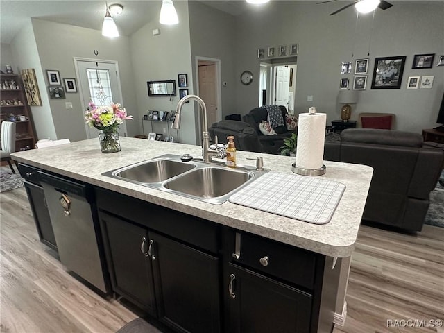 kitchen featuring lofted ceiling, sink, an island with sink, stainless steel dishwasher, and light wood-type flooring