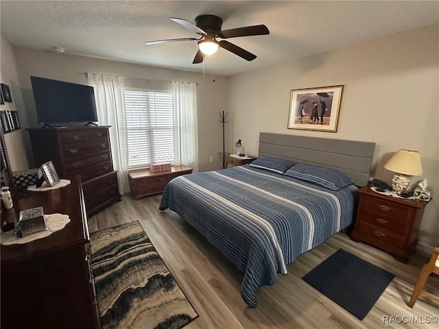 bedroom featuring a textured ceiling, light hardwood / wood-style floors, and ceiling fan