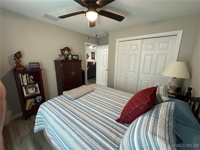 bedroom featuring hardwood / wood-style flooring, ceiling fan, and a closet