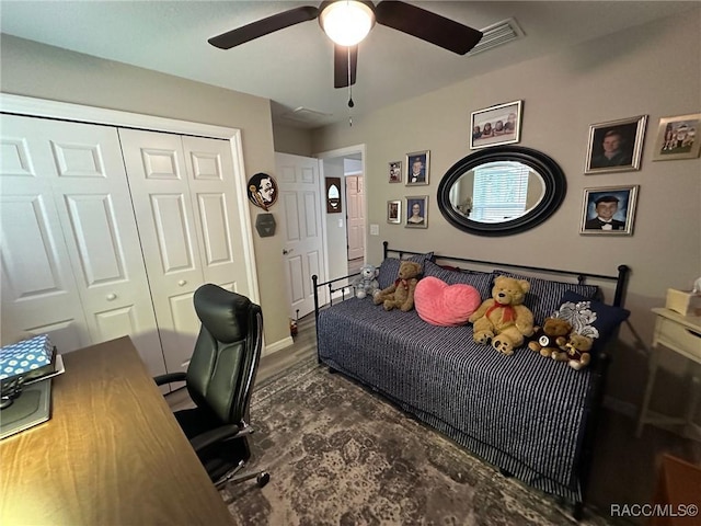 bedroom with dark hardwood / wood-style floors, a closet, and ceiling fan