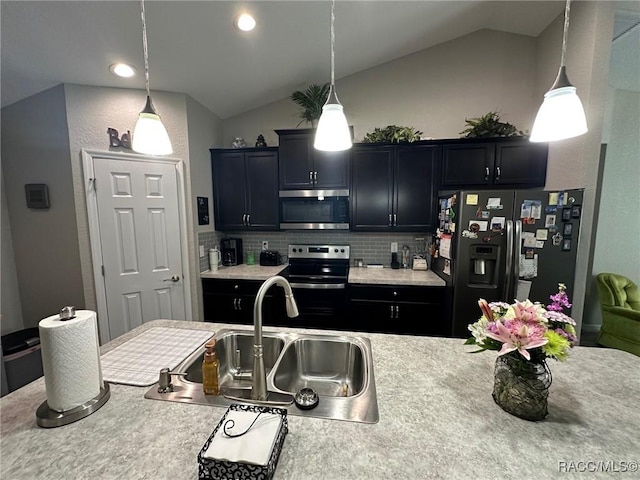 kitchen featuring hanging light fixtures, vaulted ceiling, sink, and appliances with stainless steel finishes