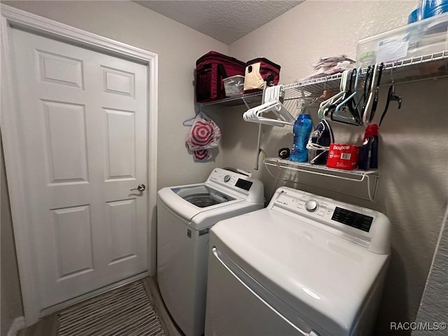 clothes washing area featuring independent washer and dryer and a textured ceiling